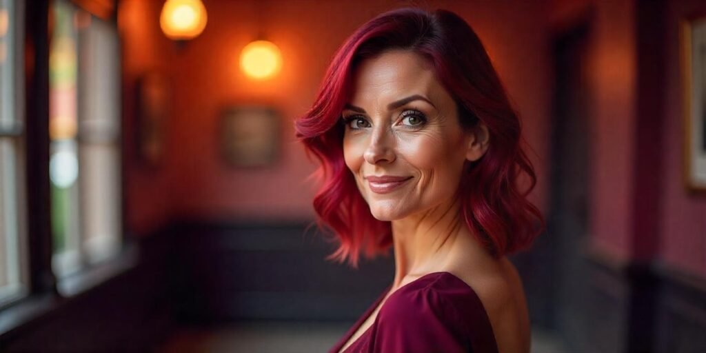 "Realistic photo of a woman over 50 with violet red hair, styled with waves, wearing a deep burgundy dress in a romantic setting."